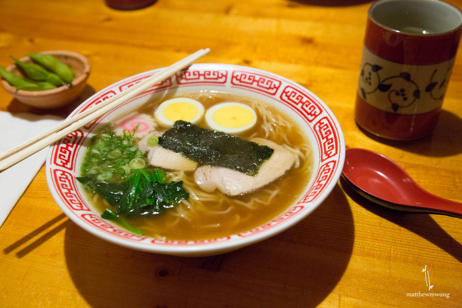 Noodles in a meat broth with slices of pork, spinach, and fish cake