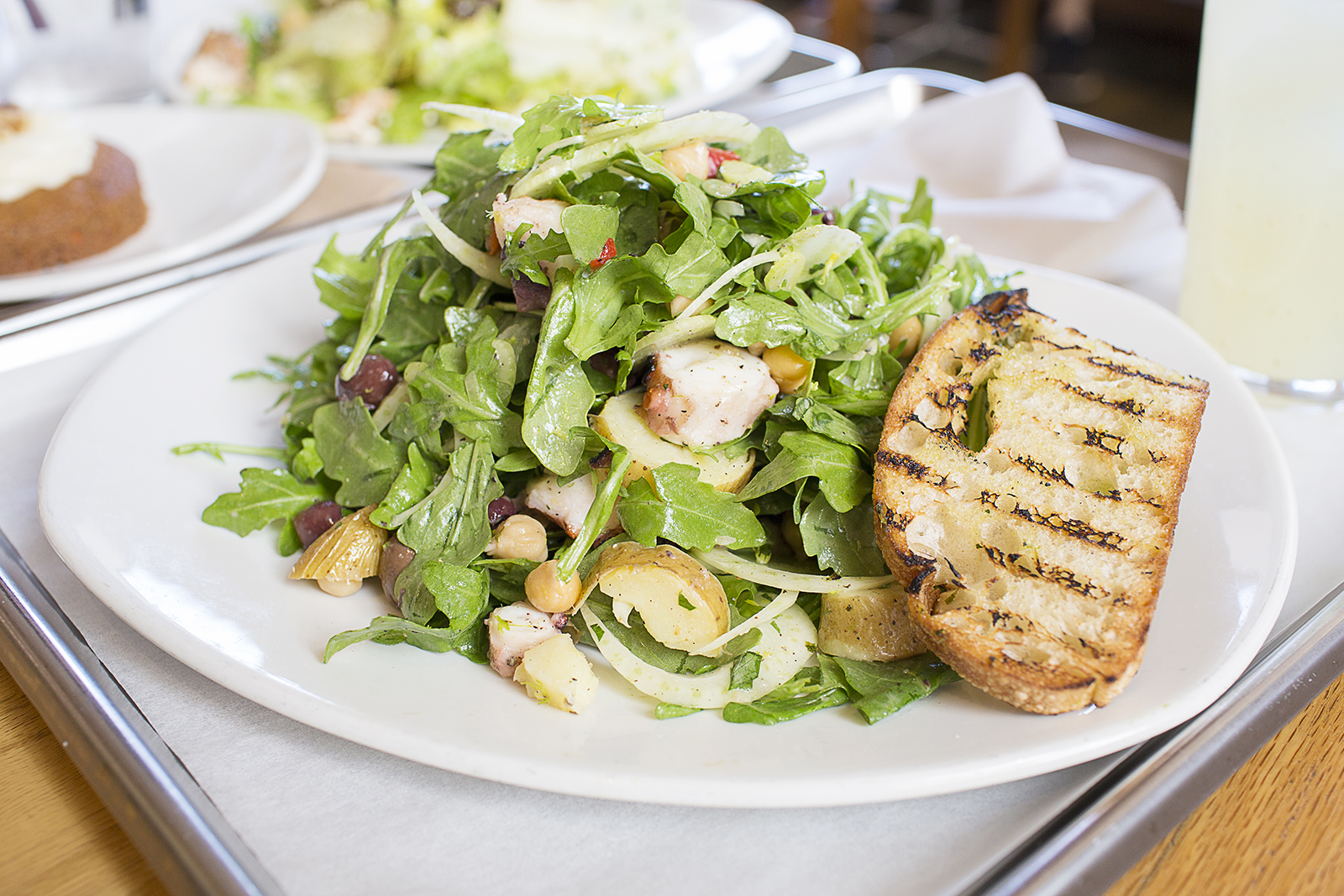 Grilled Octopus - Wild arugula, roasted fingerling potatoes, shaved fennel, marinated chickpeas, olives, grilled lemon vinaigrette