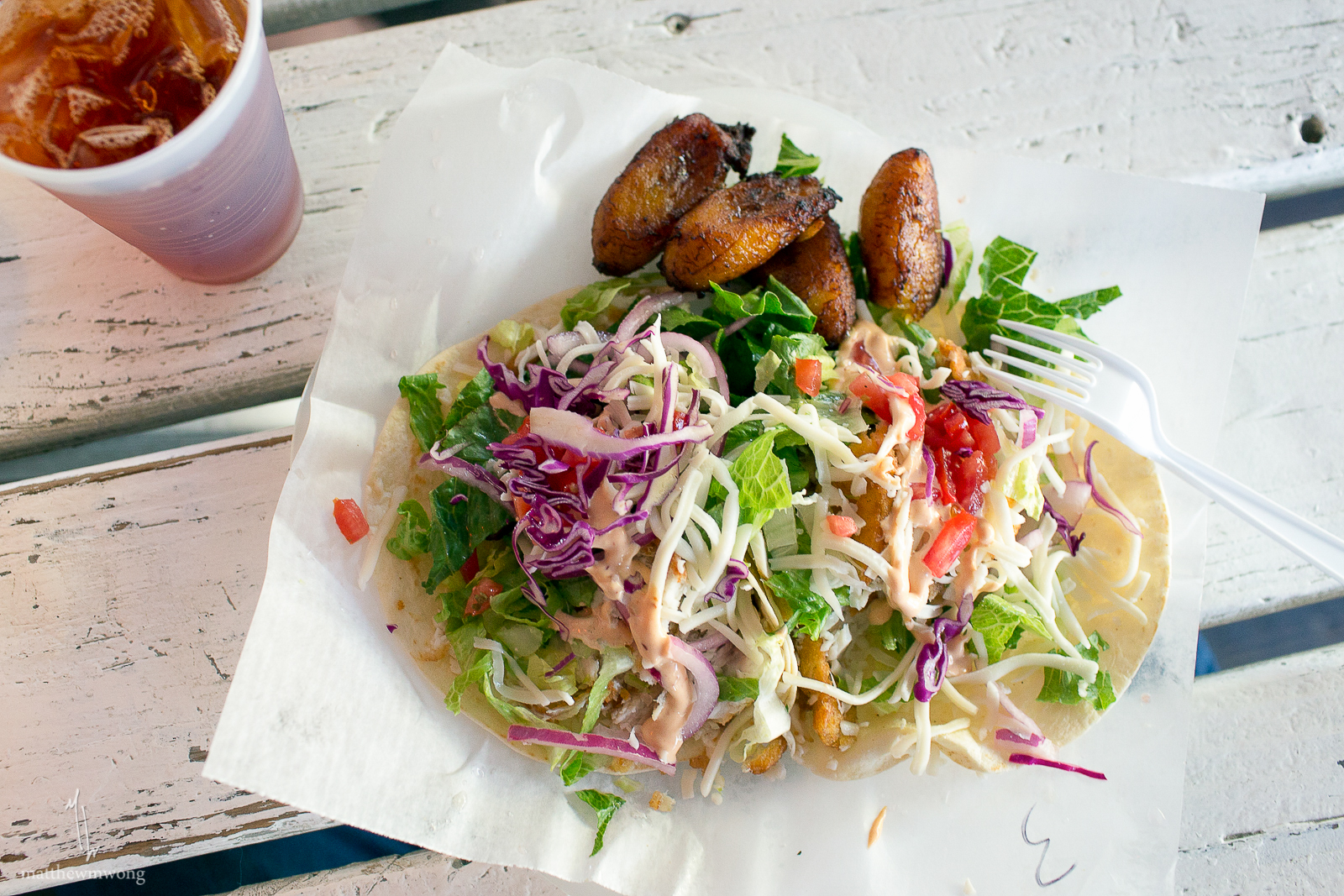 Tito's Fish Burrito - filled with fried tilapia, sweet plantain, lettuce, cheese, red onions, cilantro, chipotle sauce and a splash of tabasco sauce